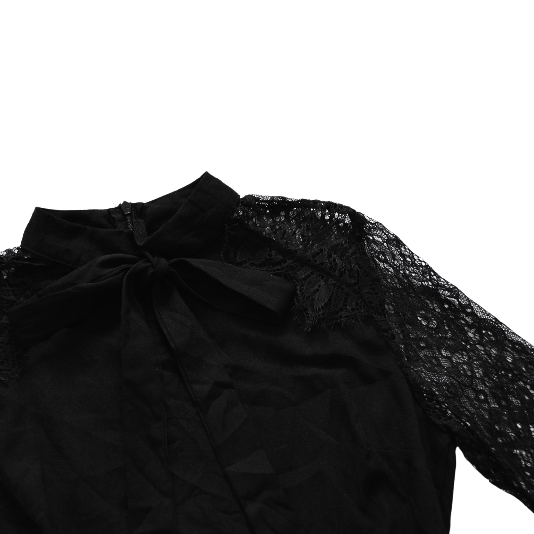 Vestido negro con moño y mangas de encaje