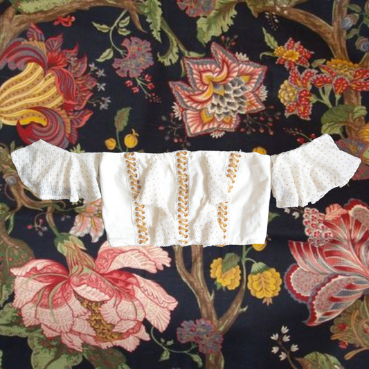 Top blanco con cadenas doradas y olanes
