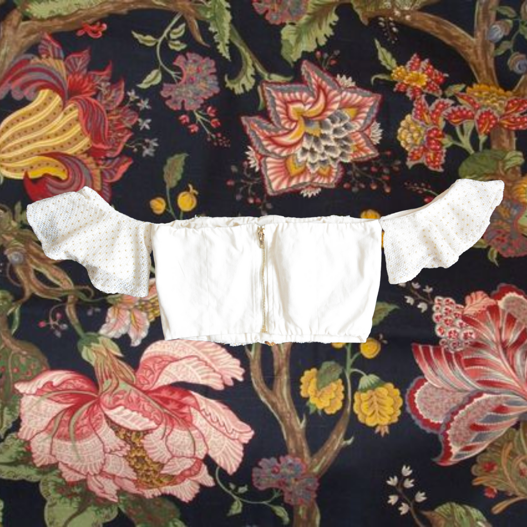 Top blanco con cadenas doradas y olanes